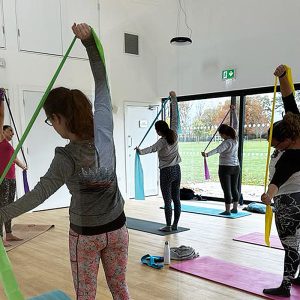 Image of a class of women doing Pilates stretching